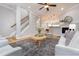 Well-lit living room showcasing hardwood floors, stairs, and an open layout to the kitchen at 2609 Stewart Pines Dr, Raleigh, NC 27615