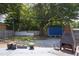 Large backyard with a blue shed, mature trees, and an outdoor fireplace feature at 2805 Fayetteville St, Durham, NC 27707
