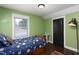 Cozy bedroom with hardwood floors, green walls, and a twin bed with space-themed bedding at 2805 Fayetteville St, Durham, NC 27707