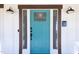 Close-up of a stylish teal front door with glass accents, complemented by farmhouse sconces at 2805 Fayetteville St, Durham, NC 27707