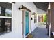 Welcoming front porch with a teal door, sconces, and view of the street at 2805 Fayetteville St, Durham, NC 27707