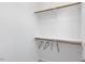 A minimalist walk-in closet with white walls, simple shelving and hanging rods at 2837 Milano Ave, Apex, NC 27502
