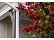 Close up featuring house number, charming wooden post and gutter system framed by vibrant flowers and foliage at 2837 Milano Ave, Apex, NC 27502