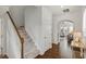 Open hallway with hardwood floors, staircase, and an arched doorway at 2837 Milano Ave, Apex, NC 27502