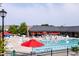 Community swimming pool and amenity center featuring a large pool, lounge chairs, tables and shade umbrellas at 2837 Milano Ave, Apex, NC 27502