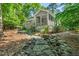 Rear exterior view of a gray home with a screened porch and rock landscaping at 289 Stoneview, Pittsboro, NC 27312