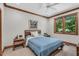 Cozy bedroom featuring a wooden bed frame, ceiling fan, and a window with wooded outdoor views at 289 Stoneview, Pittsboro, NC 27312