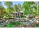 Landscaped front yard with beautiful garden beds and a charming gray home in the background at 289 Stoneview, Pittsboro, NC 27312