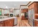 Open kitchen features stainless steel appliances, wood cabinets, granite countertops, and hardwood floors at 289 Stoneview, Pittsboro, NC 27312