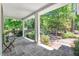 Covered porch features stone flooring, white columns, and views of the lush backyard at 289 Stoneview, Pittsboro, NC 27312