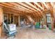 Unfinished attic space with exposed wood beams, flooring, and a window for natural light at 3 Bent Oak Ct, Durham, NC 27705