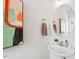 Cozy powder room features a pedestal sink, stylish mirror, and decorative artwork at 309 S Haywood St St, Raleigh, NC 27601