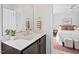 Modern bathroom vanity featuring dark wood cabinets and marble countertop, leading to bedroom at 309 S Haywood St St, Raleigh, NC 27601