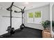 Invigorating home gym with a pull-up rack, weights, and a bright window for natural light at 309 S Haywood St St, Raleigh, NC 27601
