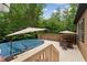 Beautiful wooden deck with outdoor seating, an umbrella, and a covered pool for relaxing at 31 River View Ct, Timberlake, NC 27583