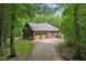 View of house with attached garage and long driveway, surrounded by lush greenery at 31 River View Ct, Timberlake, NC 27583