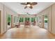 Bright sunroom with wood floors, multiple windows offering scenic views, and comfortable seating arrangements at 31 River View Ct, Timberlake, NC 27583