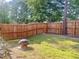 Spacious backyard featuring a wooden fence, fire pit and mature trees at 312 Crusaders Dr, Morrisville, NC 27560