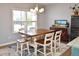 Well-lit dining room with a wooden table, six chairs, a chandelier, and a large window with a view at 312 Crusaders Dr, Morrisville, NC 27560