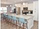Bright kitchen featuring an island with seating, white cabinets, stainless steel appliances, and modern lighting at 312 Crusaders Dr, Morrisville, NC 27560