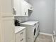 Functional laundry room with white cabinets, modern washer and dryer, and ample counter space for folding at 312 Crusaders Dr, Morrisville, NC 27560