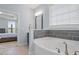 Bright bathroom with soaking tub and tile accent wall that separates the tub from the bedroom at 337 Brinkley Cir, Mebane, NC 27302