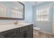 Well-lit bathroom featuring a shower-tub combo, modern vanity, window and blue accent walls at 337 Brinkley Cir, Mebane, NC 27302