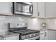 The kitchen features modern stainless steel appliances and white subway tile backsplash at 337 Brinkley Cir, Mebane, NC 27302
