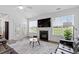 Living room with a fireplace, mounted television, access to outdoor space, and large windows with natural light at 337 Brinkley Cir, Mebane, NC 27302