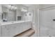 Bright bathroom features a double sink vanity with white cabinets, a walk-in shower, and tile flooring at 3400 Secretariat Way, Raleigh, NC 27614