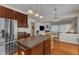 Well-lit kitchen boasts dark cabinets, stainless steel appliances, and an island with stone countertops at 3400 Secretariat Way, Raleigh, NC 27614