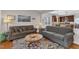 Inviting living room with an open floorplan and view of the kitchen, featuring wood floors and comfortable seating at 3400 Secretariat Way, Raleigh, NC 27614