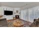 Inviting living room with a cozy fireplace, built in shelving, wood floors, and bright natural light at 3400 Secretariat Way, Raleigh, NC 27614