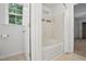 Bathroom features a bathtub with shower, a window, and access to another room at 353 Spearhead Pl, Clayton, NC 27520