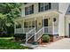 Inviting front porch with classic design elements and meticulously landscaped flower beds at 353 Spearhead Pl, Clayton, NC 27520