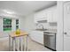 Bright kitchen with white cabinets, stainless steel dishwasher, sink and a wooden kitchen island next to a bay window at 353 Spearhead Pl, Clayton, NC 27520