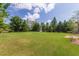 Large backyard with beautiful green lawn and tall trees providing ample shade at 401 Dyersville Dr, Morrisville, NC 27560