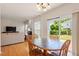 Open concept dining room with hardwood floors and view to backyard through sliding glass door at 401 Dyersville Dr, Morrisville, NC 27560