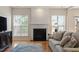 Cozy living room featuring a fireplace with decorative mantel and large windows at 401 Dyersville Dr, Morrisville, NC 27560