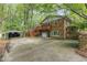 Back exterior view of brick home featuring ample parking and a convenient drive-under garage at 4030 King Charles Rd, Durham, NC 27707