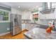 Well-lit kitchen with stainless steel refrigerator and views of the wooded exterior at 4030 King Charles Rd, Durham, NC 27707