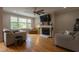 Cozy living room featuring hardwood floors, a fireplace, and natural light from large windows at 441 Heritage Village Ln, Apex, NC 27502