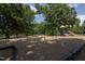 Community playground with swings, slides, and wood chip ground cover at 441 Heritage Village Ln, Apex, NC 27502
