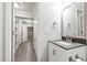 Charming bathroom vanity with gray countertop, mirror, brushed bronze hardware, and convenient built-in shelving at 4906 Lakemont Dr, Raleigh, NC 27609