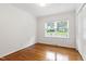 Light-filled bedroom with gleaming hardwood floors and a large window providing a serene view at 4906 Lakemont Dr, Raleigh, NC 27609