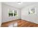 Bright bedroom with hardwood floors, white walls, and two windows that allow natural light to fill the space at 4906 Lakemont Dr, Raleigh, NC 27609