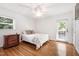 Charming bedroom featuring hardwood floors, neutral walls, a ceiling fan, and a door to the outside at 4906 Lakemont Dr, Raleigh, NC 27609