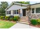 Close-up of the home's entrance, featuring stone accents, well manicured shrubs and new looking front steps at 4906 Lakemont Dr, Raleigh, NC 27609