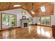 Bright living room features wood ceiling, hardwood floors, a stone fireplace, and multiple windows at 4906 Lakemont Dr, Raleigh, NC 27609