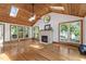Open living room featuring wood ceiling, hardwood floors, stone fireplace and view of the porch at 4906 Lakemont Dr, Raleigh, NC 27609